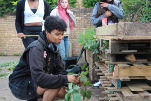 A young person helps build a 'bug hotel' to increase biodiversity at their youth club.