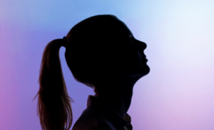 Woman with long hair silhouetted on a purple and blue background.