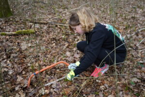 Scotland's Young People's Forest member cutting a tree