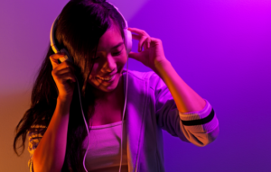 Young woman listening to music with headphones on.
