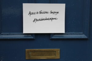 Picture of a blue door with a note on it that says 'Access to Facilities Campaign. #YouthWorkNeedsAHome