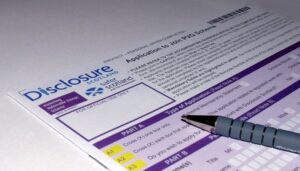 Close up shot of a Disclosure Scotland PVG form with a pen lying on top of it