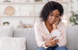 Sad young women holding mobile phone