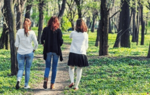 Three young women walking in a park