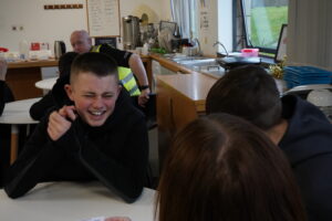 Two young pupils laughing at a table in a classroom environment