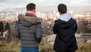 Two young people looking out over city landscape