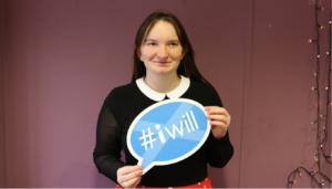 #IWill ambassador Rachael stands holding #IWill sign