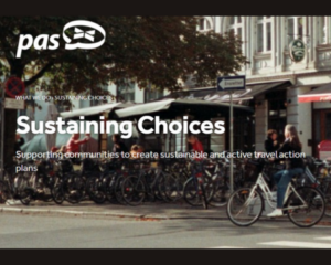 Picture of a cafe with lots of bikes outside it. PAS logo in the top left. Text reads 'What We Do> Sustaining Choices. Sustaining Choices. Supporting communities to create sustainable and active travel action plans.